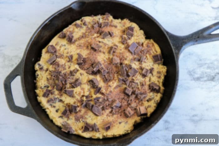 A large chocolate chip skillet cookie, golden-brown and bubbling with melted chocolate.