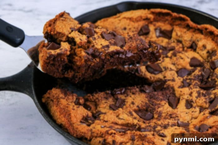 Another perspective of a cast iron skillet cookie with melted chocolate and golden edges.