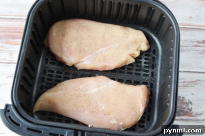 Perfect Air Fryer BBQ Chicken Breast 4 Air Fryer Chicken breasts coated in seasoning, ready to be cooked to perfection.