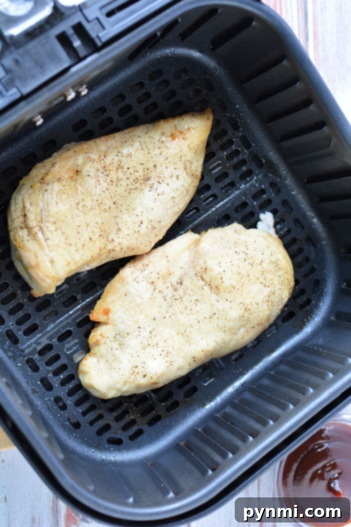 Perfect Air Fryer BBQ Chicken Breast 5 Plate of delicious air fryer BBQ chicken slices drizzled with extra sauce.