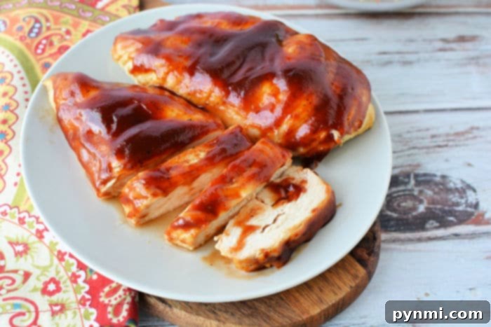 Perfect Air Fryer BBQ Chicken Breast 9 Two pieces of succulent barbecue chicken, artfully presented on a white serving dish.