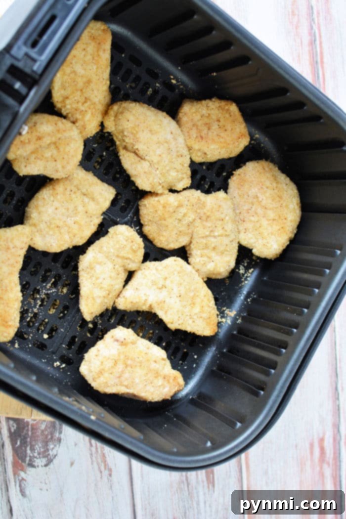 Crispy Air-Fried Boneless Chicken Bites 8 A basket full of golden-brown air fryer boneless chicken wings, ready to be tossed in sauce, highlighting a healthy and easy meal option.