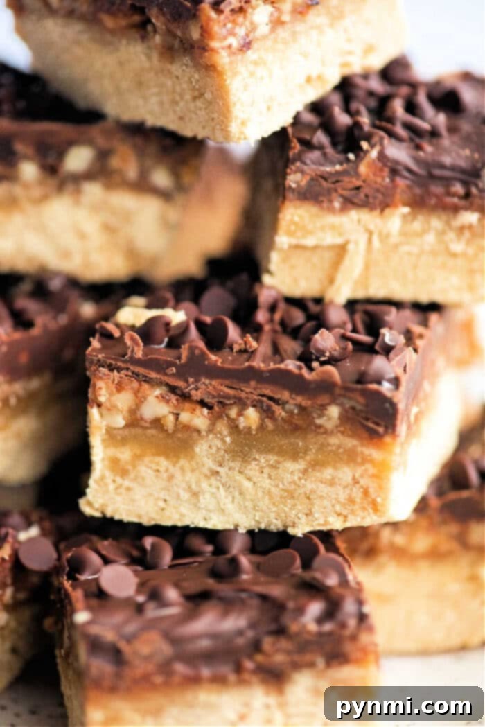 Buttery Pecan Shortbread Squares 2 Delicious pecan shortbread bars, layered with golden cookie, rich caramel, and dark chocolate, perfect for holiday dessert tables.