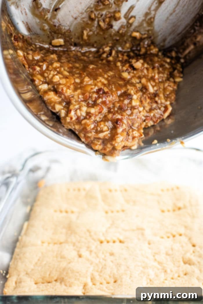 Buttery Pecan Shortbread Squares 4 A tray of freshly baked pecan pie bars, glistening with a caramel glaze and topped with chopped pecans, cooling on a wire rack.