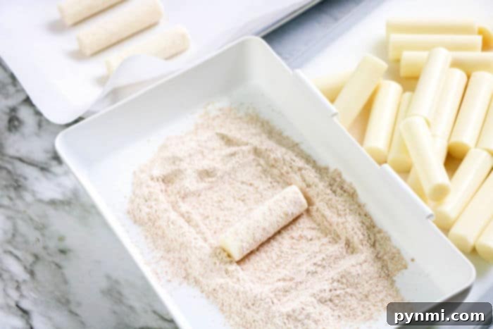 Crispy Homemade Air Fryer Mozzarella Sticks 7 A basket full of homemade air fryer mozzarella sticks, showcasing their golden-brown color and crispy texture.
