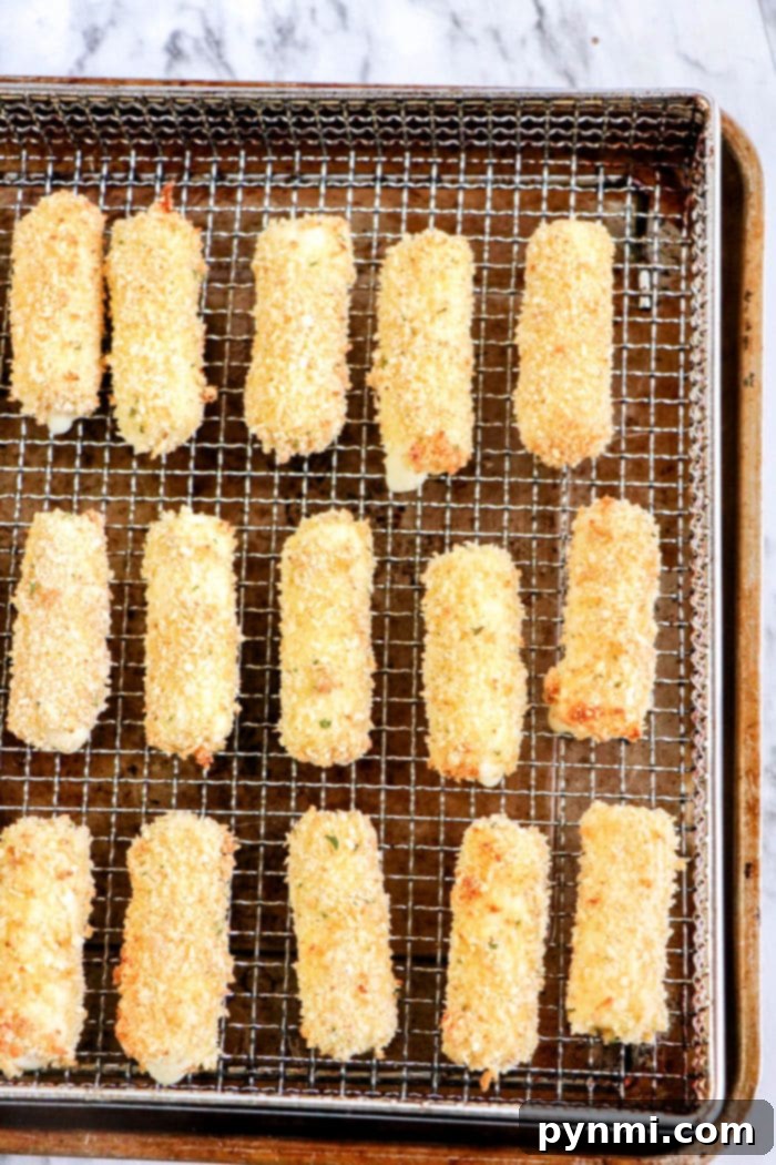 Crispy Homemade Air Fryer Mozzarella Sticks 9 A large batch of homemade air fryer mozzarella sticks neatly arranged, showcasing their consistent golden-brown crust.