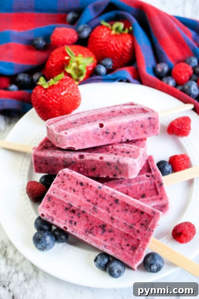 A close-up shot of mixed berry popsicles, showing the layered texture and vibrant colors from various fruits, ready to be enjoyed as a cool treat.