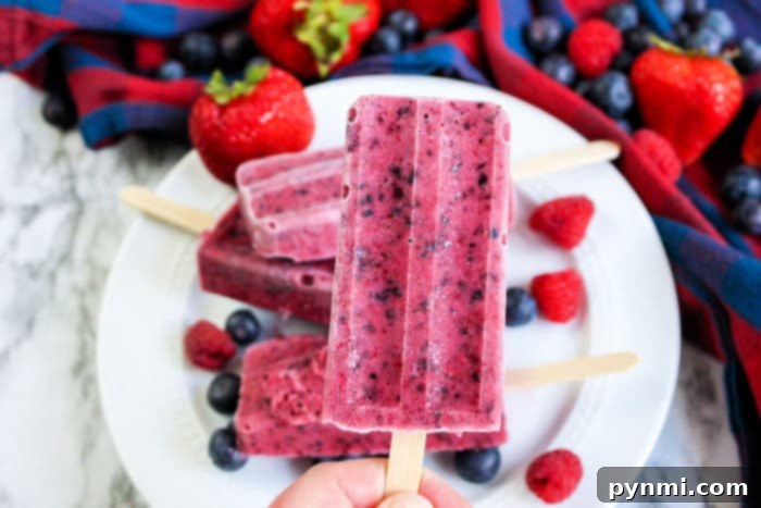 A vibrant homemade strawberry popsicle, showcasing its rich, natural red color and refreshing appearance, emphasizing a healthy dessert option.