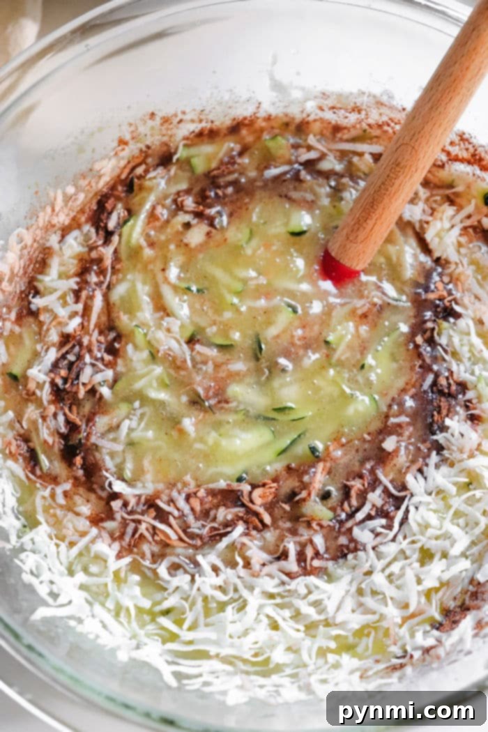 Tropical Coconut Zucchini Loaf 4 Close-up of shredded zucchini on paper towels, demonstrating moisture removal technique for baking