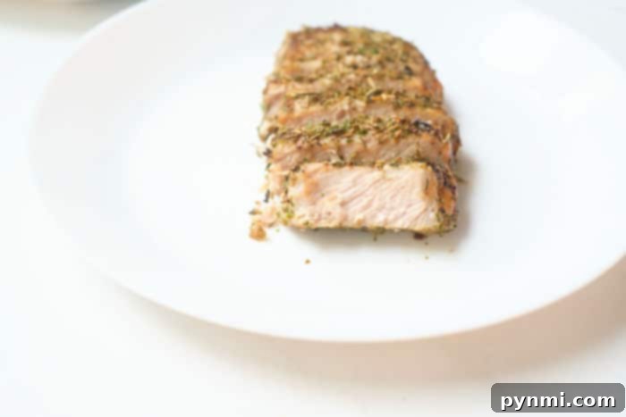 Perfect Air Fryer Pork Steak 8 Cooked pork steak on a plate with blurred background, ready to be served.