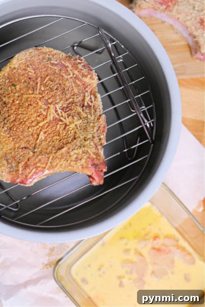 Ninja Foodi breaded Pork Chops arranged in the air fryer basket.