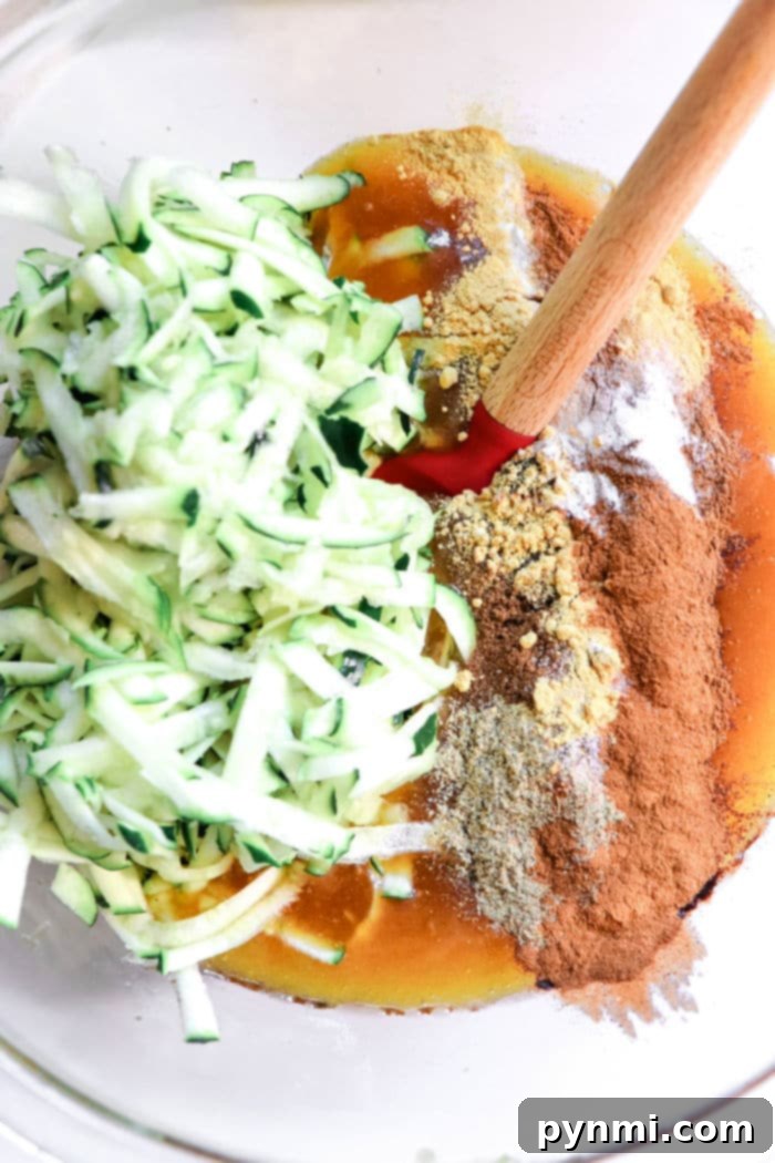 A freshly baked Zucchini Gingerbread Loaf, golden brown with a perfect crack, on a wooden board.