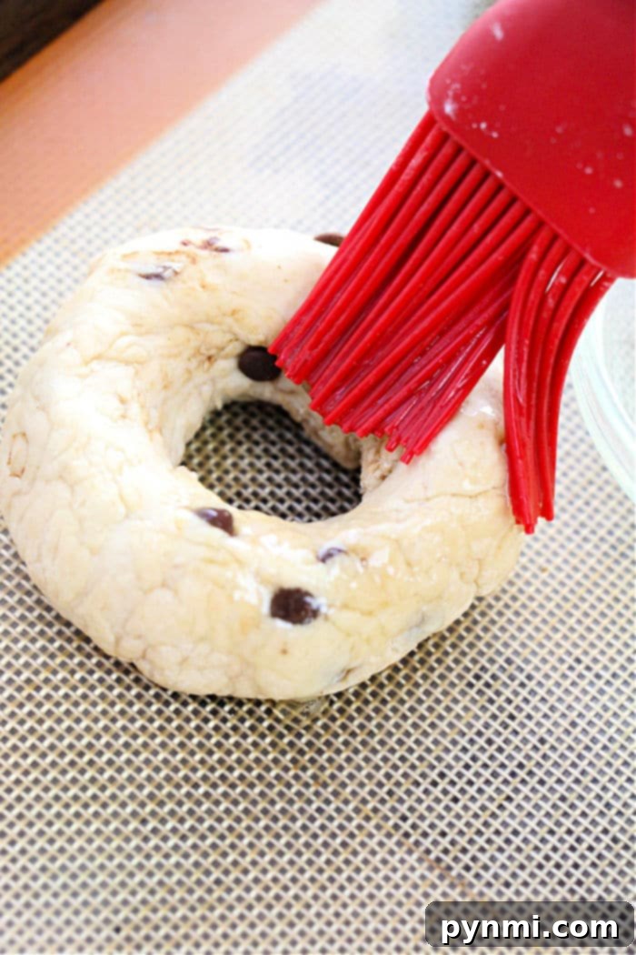 Effortless Two-Ingredient Bagels 4 Step-by-step image of how to make bagels, showing the dough being shaped into traditional rings on a baking sheet.