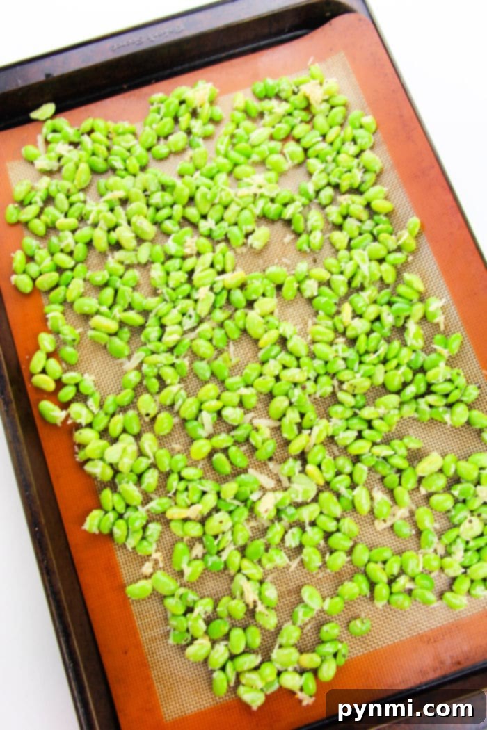 Crispy Roasted Edamame 4 Ingredients for oven-roasted edamame laid out: shelled edamame, olive oil, garlic powder, and salt, ready for mixing.