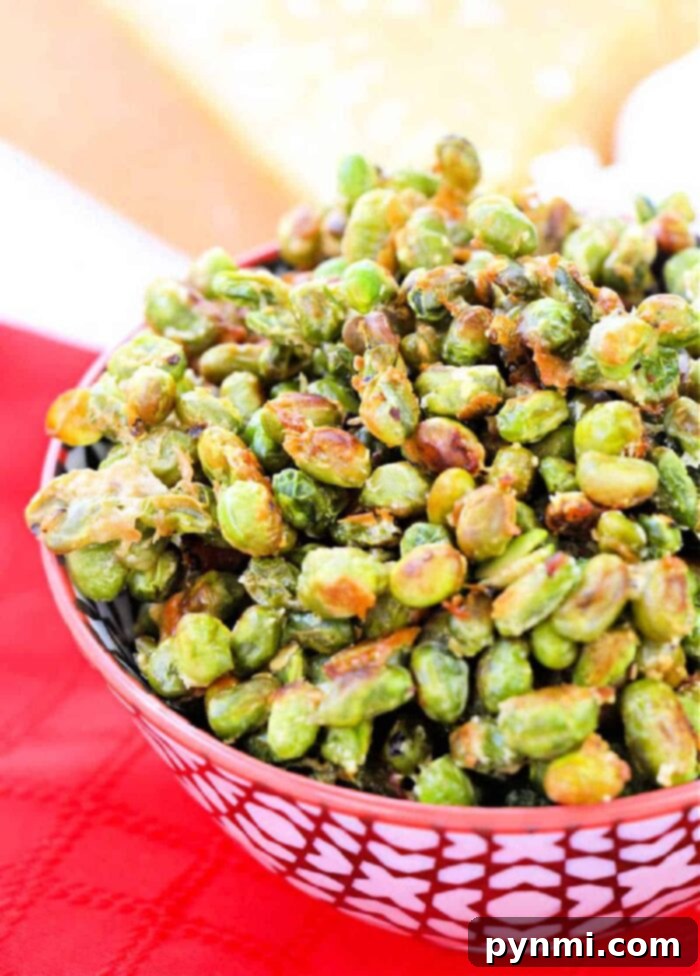 Crispy Roasted Edamame 8 Overhead view of roasted edamame scattered on a baking sheet, illustrating the even distribution and golden-brown spots.
