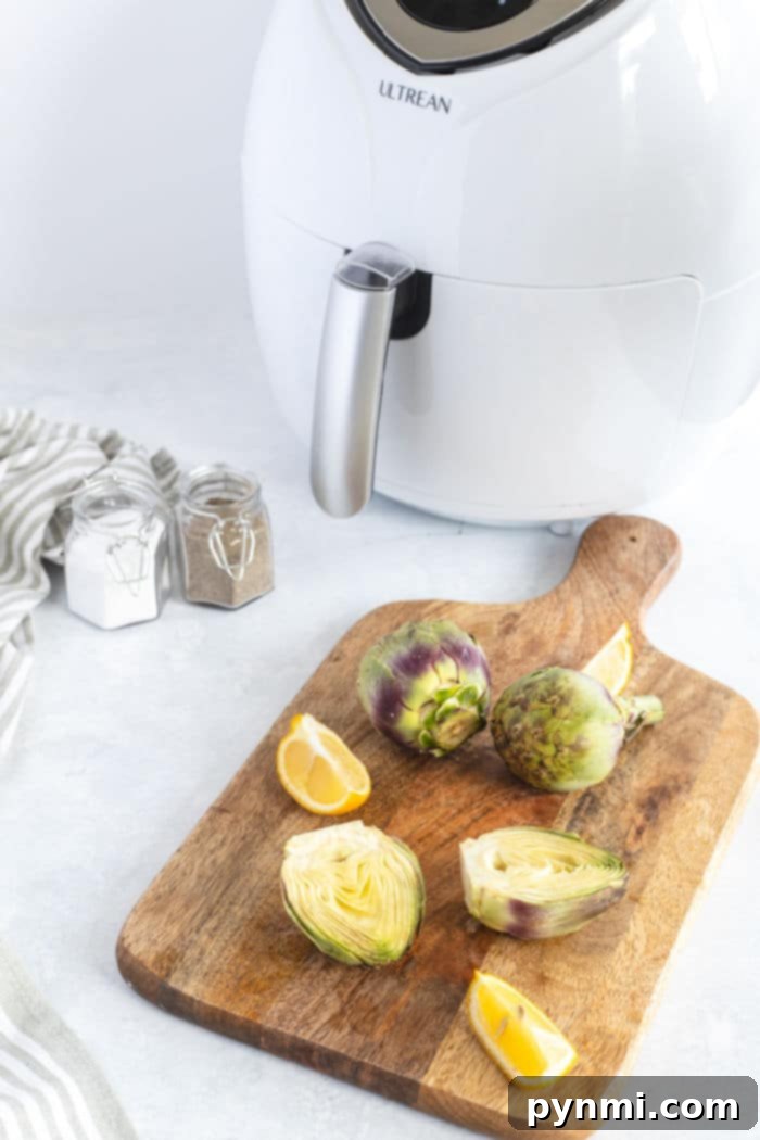 Crispy Air Fryer Artichoke Hearts 3 Artichokes and lemon slices rest elegantly on a wooden board, accompanied by an air fryer artichoke creation and various spice jars.