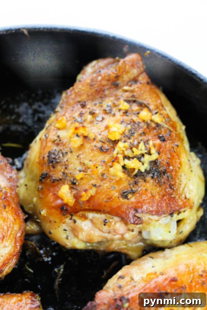 Juicy Garlic Butter Bone-In Chicken Thighs 6 A single garlic butter chicken thigh, beautifully browned and garnished with herbs, ready to be served.