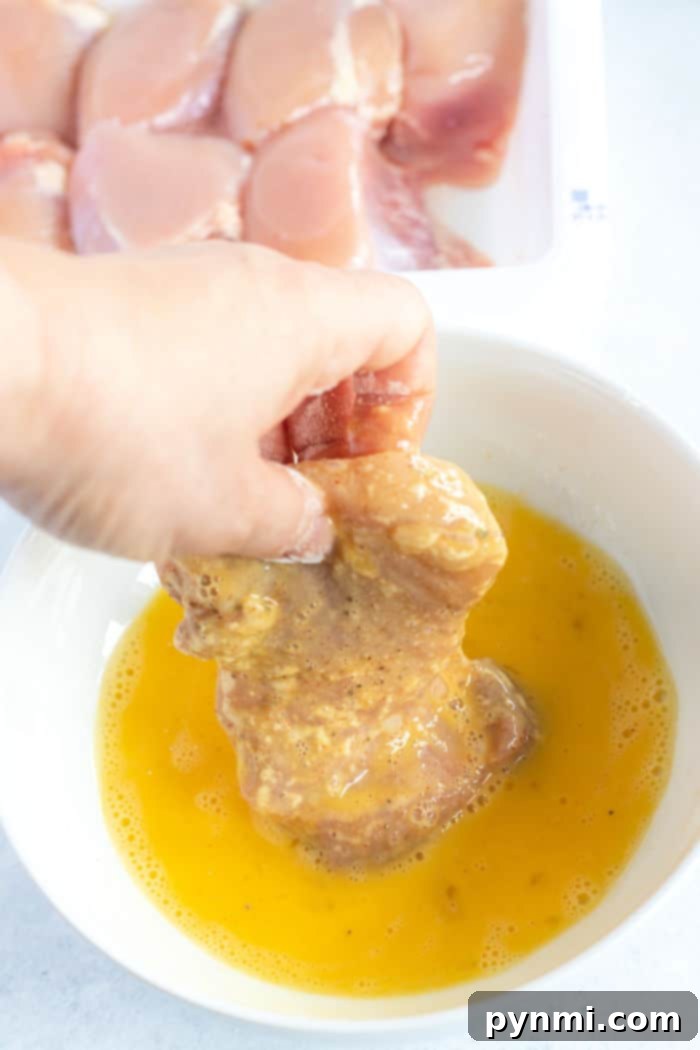 A close-up of perfectly cooked boneless chicken thighs in an air fryer, golden and crispy, ready to be served.