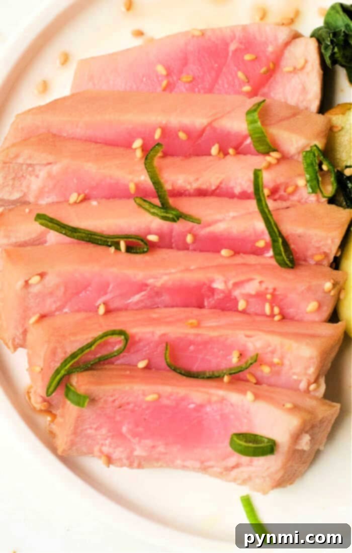 Perfectly seared air fryer tuna steak, showing a pink interior and golden-brown crust.