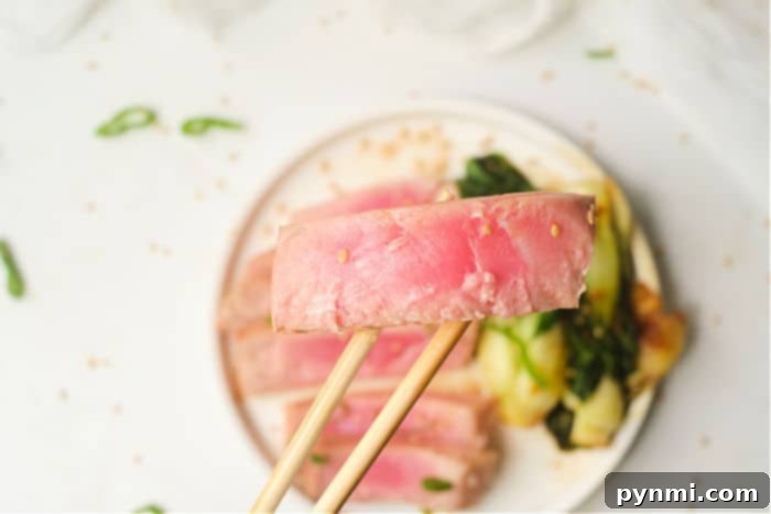 Two beautifully seared tuna steaks on a serving board, ready to be sliced.