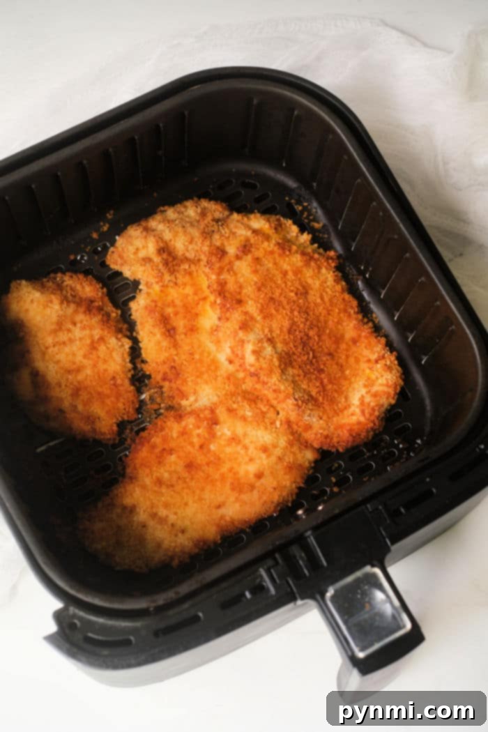 Sliced Chicken Katsu in air fryer basket, ready to be served