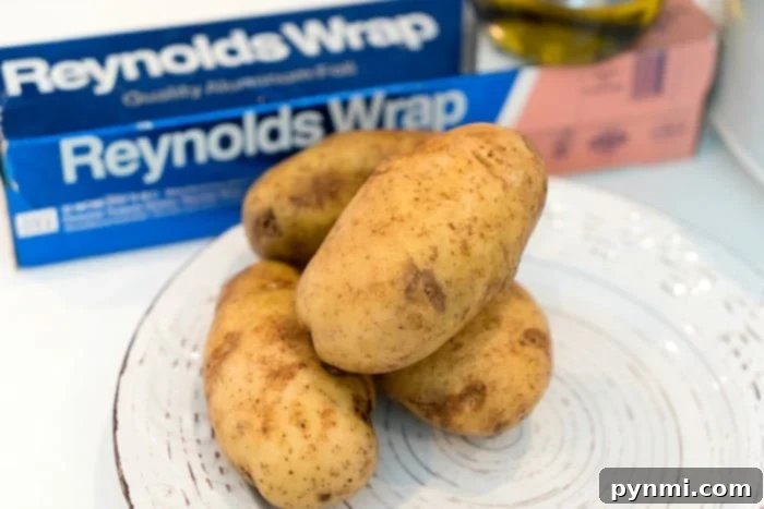 How to cook potatoes in the crockpot Slow cooker baked potatoes ready to be wrapped in foil.