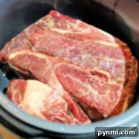 Effortless Instant Pot Frozen Chuck Roast 7 A frozen chuck roast, beautifully marbled, sits in the pressure cooker pot, ready for magic in the Instant Pot.