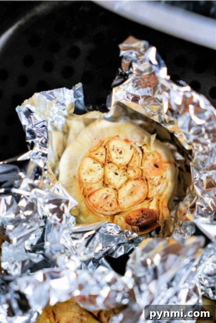 A basket of perfectly roasted air fryer garlic bulbs, showcasing the ease of this cooking method.