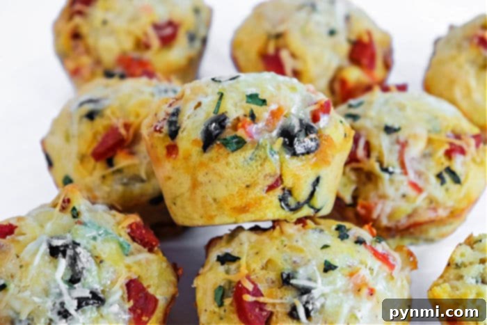 Savory Pizza Bites 6 A top-down view of freshly baked pizza muffins in a metal muffin tin, showcasing their golden crust and savory toppings.