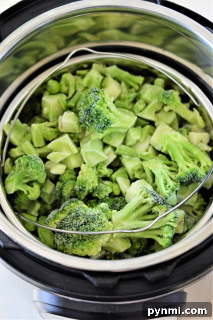 Frozen broccoli being cooked in an Instant Pot using a steamer basket for optimal results.