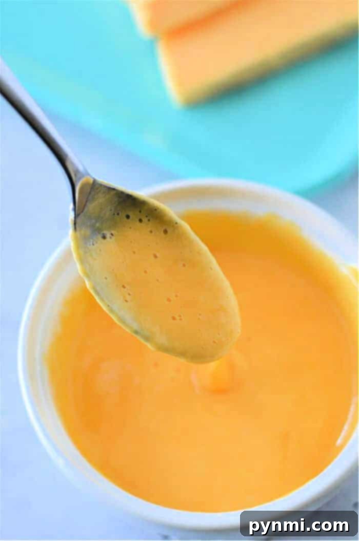 Whip Up Perfect Velveeta Cheese Sauce Every Time 2 Homemade Velveeta Cheese Sauce, smooth and orange in a bowl, ready to be served.