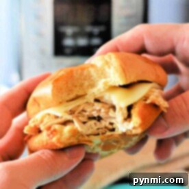 Easy Instant Pot Mississippi Chicken 6 Hands holding a sandwich with shredded Mississippi chicken seasoning in front of an Instant Pot.