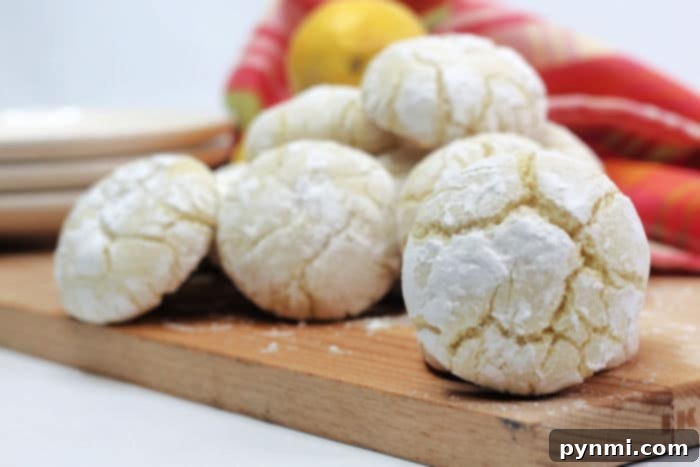 Close-up of freshly baked lemon crinkle cookies with vibrant powdered sugar coating.