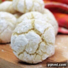Close-up of a powdered lemon crinkle cookie on a wooden board, showcasing the delightful results of a cherished lemon crinkle cookie recipe.