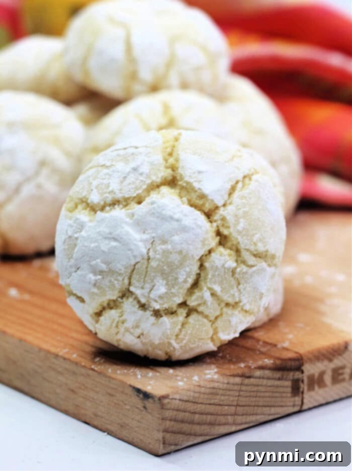 A plate full of freshly baked, perfectly crinkled lemon cookies, ready to be enjoyed.