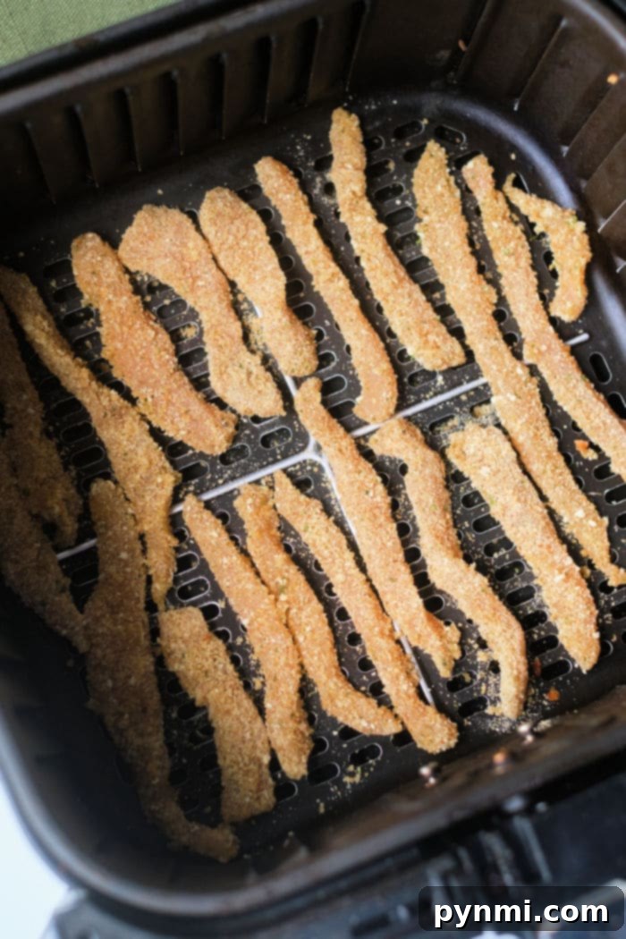 chicken fries cooking in a Ninja Foodi air fryer basket