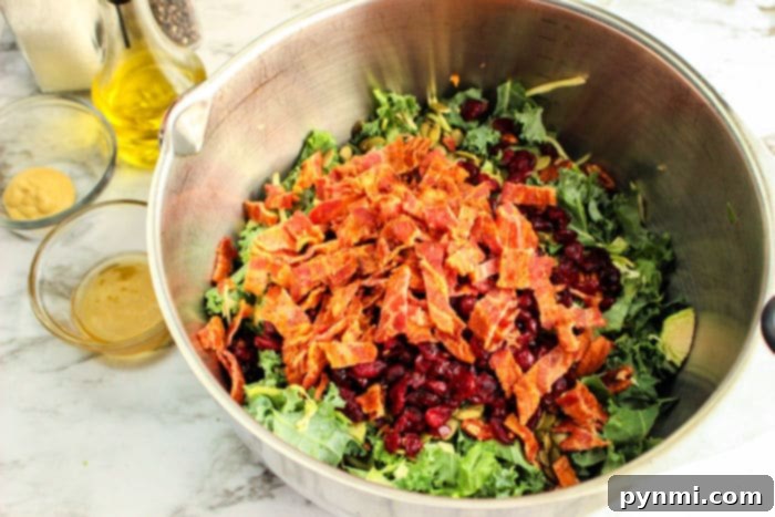 A close-up of the delicious kale and Brussels sprout salad with added cranberries and pecans, glistening with dressing.