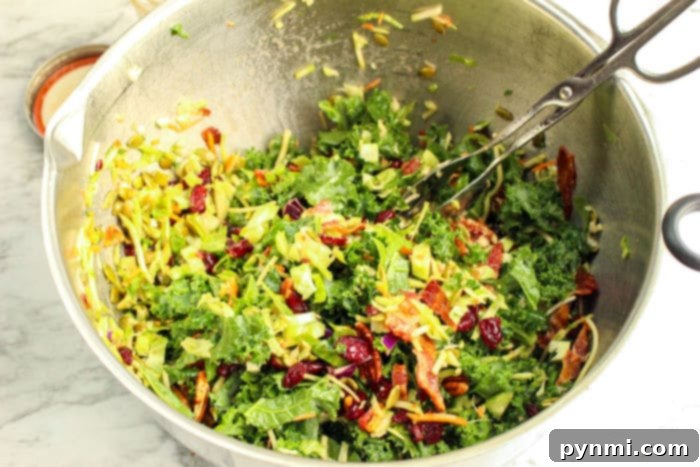 A wider shot of the kale and shredded Brussels sprout salad in a white bowl, ready for serving.