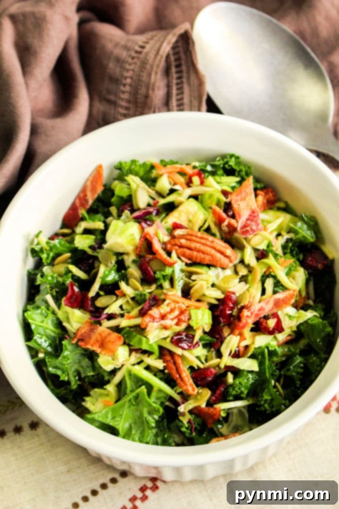 An overhead shot of a large bowl of shredded Brussels sprout salad, showcasing the texture and vibrant ingredients.