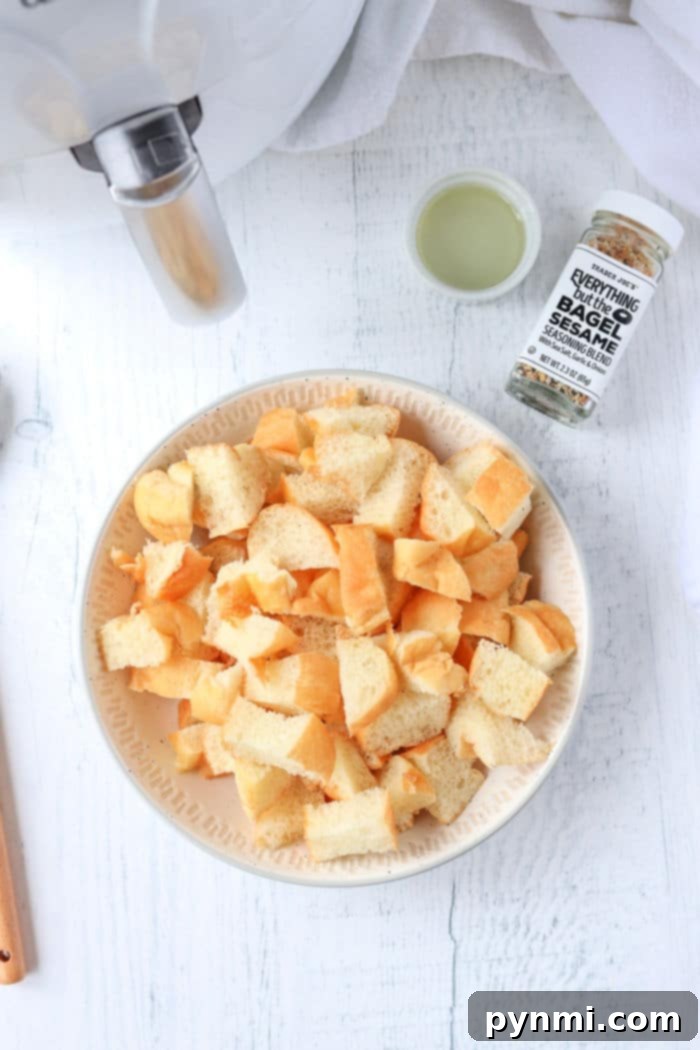 Close-up of golden, perfectly toasted homemade croutons scattered on a white surface.
