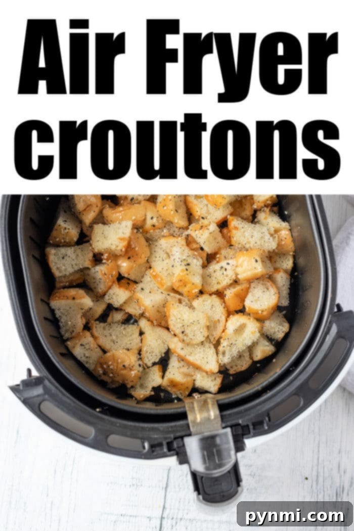 A crisp air fryer basket brimming with golden, seasoned croutons sits on a pristine white background with text 'Air Fryer Croutons'.