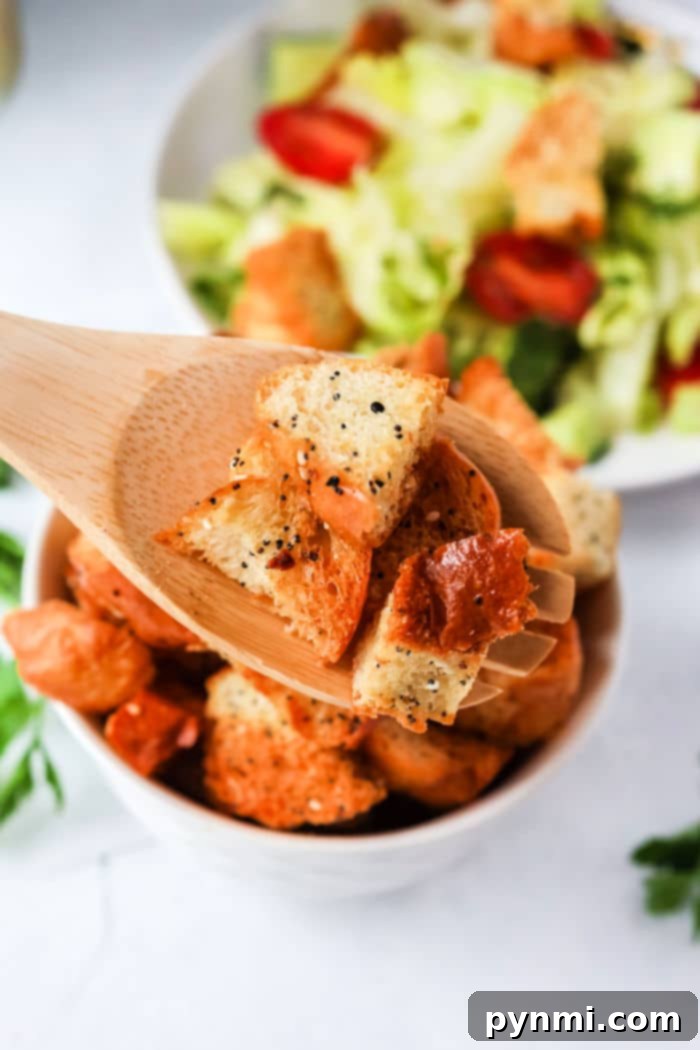 Air fryer basket filled with crispy, seasoned croutons, showcasing their golden texture.