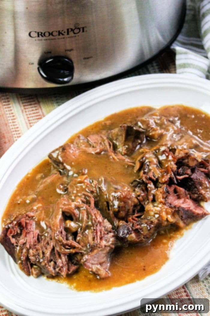 Tender Slow Cooker Roast Beef and Gravy served on mashed potatoes