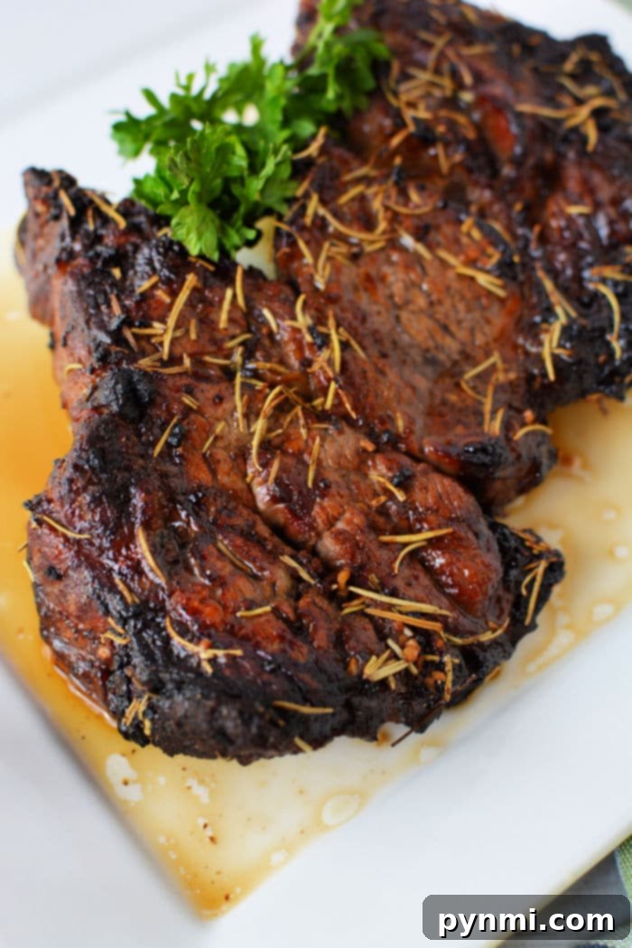 Ultimate Air Fryer Chuck Roast 7 Air fried chuck roast with rosemary and garnish on a white plate