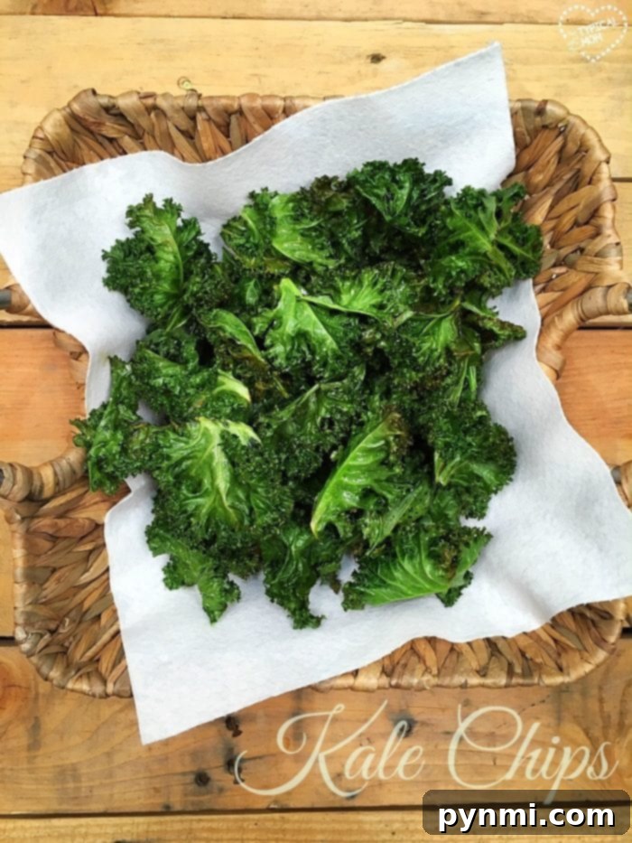 A bowl of vibrant green, perfectly crispy kale chips, ready to be devoured as a healthy, homemade snack.