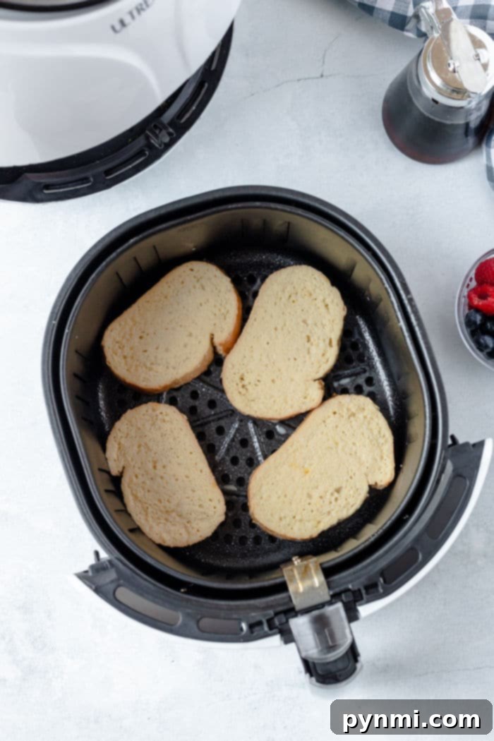 Freshly air-fried French toast, perfectly golden brown, arranged in the air fryer basket.