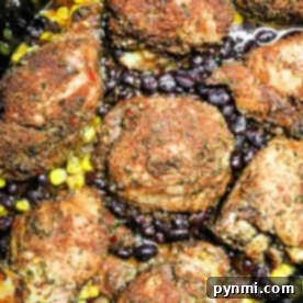 Seasoned chicken thighs with black beans and corn in a crockpot, richly spiced to create a jerk chicken masterpiece cooked to perfection.