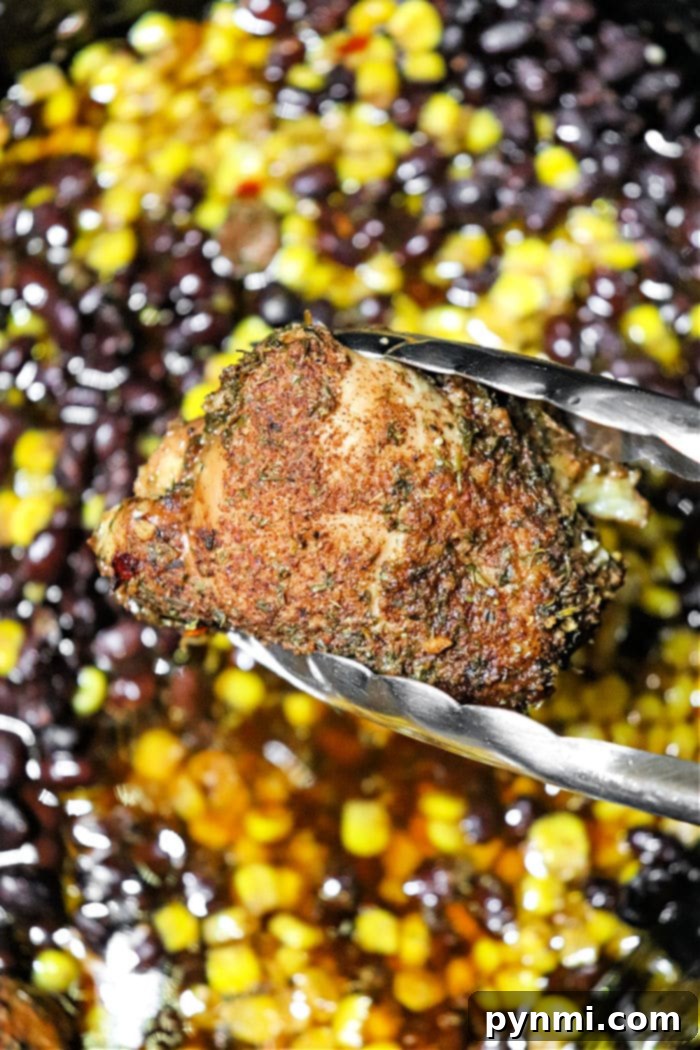 A vibrant plate of Crockpot Jerk Chicken with black beans and corn, garnished for serving.