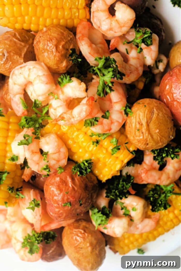 Air Fryer Seafood Boil Twist 2 A vibrant air fryer shrimp boil with perfectly cooked shrimp, golden potatoes, and bright yellow corn on the cob, seasoned to perfection.