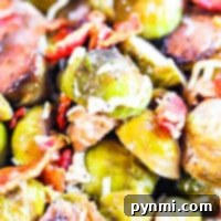 Close-up of roasted Brussels sprouts with crispy bacon bits and melted cheese, slow-cooked to perfection in a crockpot.